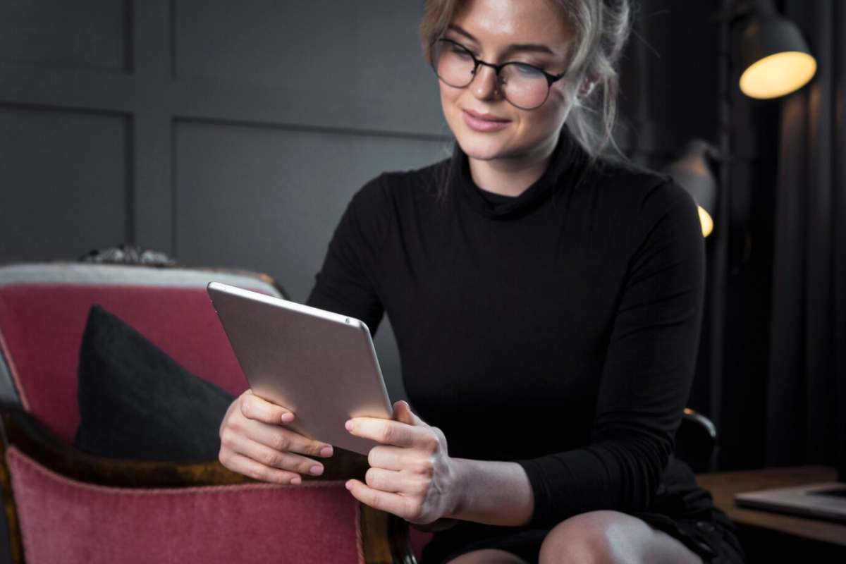 Una ragazza con gli occhiali che legge un ebook