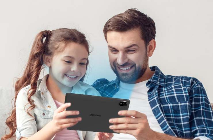 papà e figlia di fronte a un tablet illuminato