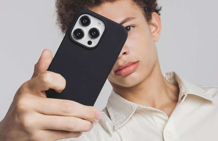 un ragazzo con un iphone in mano