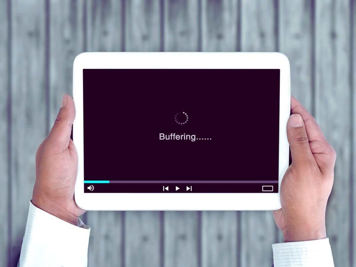 persona che tiene in mano un tablet con un video in buffering