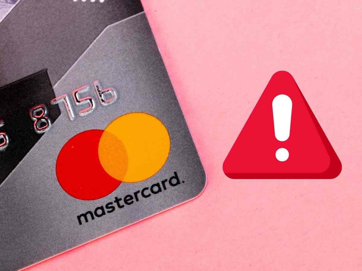 carta mastercard con logo e segnale di pericolo su sfondo rosa