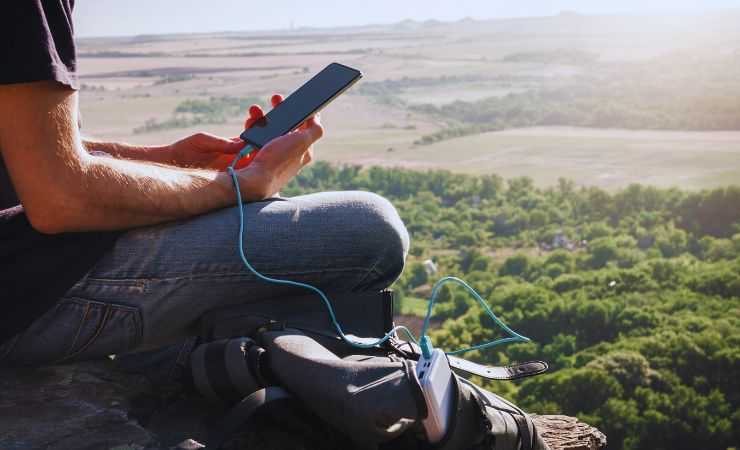 ragazzo carica smartphone all'aperto